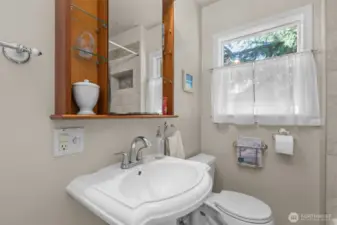 Full bathroom (main floor) has tiled shower with built-in shelf, ceramic tile flooring, and small closet.