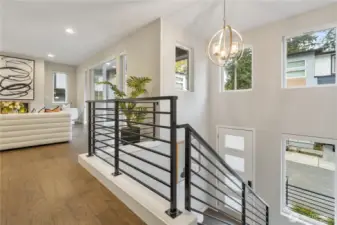 Soaring ceilings, walls of windows, and upscale finishes set the tone with hardwood floors, modern metal railings