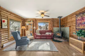 Cozy great room centered around a charming wood stove with brick hearth — the perfect gathering space on crisp Chelan evenings. Large windows bring in natural light and views of the peaceful setting.