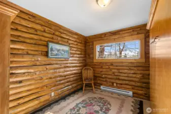 Bedroom with Murphy Bed -  Versatile bedroom with built-in Murphy bed offers flexibility for guests, office space, or hobbies—comfortably blending functionality with the home’s warm log cabin character.