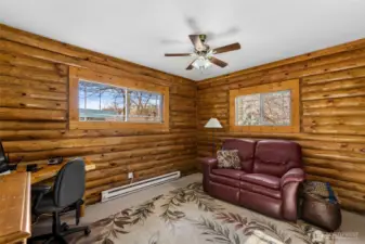 Study or Guest Bedroom -  Ideal as a home office, study, or additional bedroom, this light-filled space offers peaceful views and classic log walls—perfect for remote work or welcoming overnight guests.