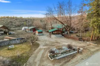 Bird’s-eye view of the full property layout -showcasing home, shop, well house, pole barn, and covered parking — all thoughtfully arranged for function and privacy.