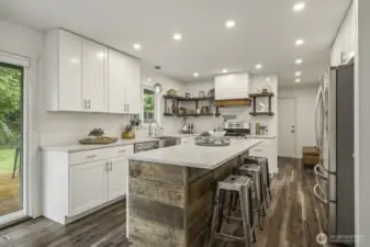 Bright and modern kitchen with white cabinets, sleek quartz surfaces, and a generous island.