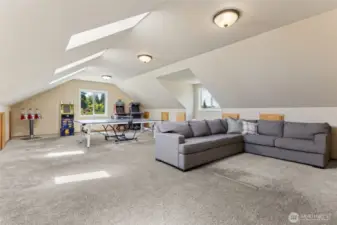 This oversized bonus room is the ultimate hangout—set up for games, lounging & fun, w/ built-in storage, a full closet, skylights & windows that keep the energy bright & inviting