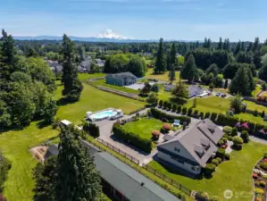 Side view of the home captures its impressive scale & architecture—set against the stunning backdrop of Mt. Rainier, blending natural beauty with timeless design