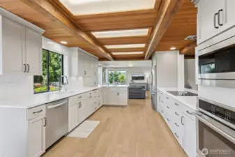 Open-concept kitchen features sleek wall ovens, an inset cooktop, & seamless flow into every area of the home—designed for effortless living & entertaining