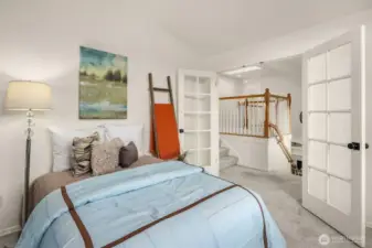 Off the staircase between the main and upper level are French doors that open up to a flex room with a closet. This room could be a den or potential 5th upstairs bedroom which is how it is currently staged.