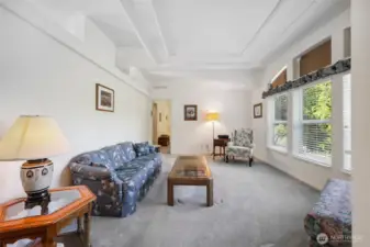 Welcoming space with carpet and entry to the Primary Suite.