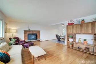 Gorgeous hardwoods surround a wood stove in this roomy living room space