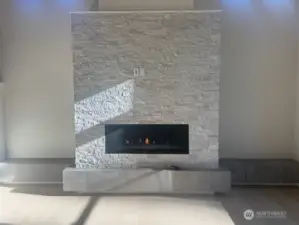 linear gas fireplace with stone facade and raised tile hearth