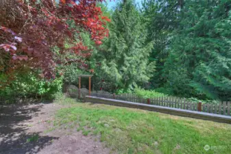 The property extends past the fence into the trees.