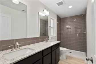 Double vanity and walk in shower with timeless tile and counter tops.