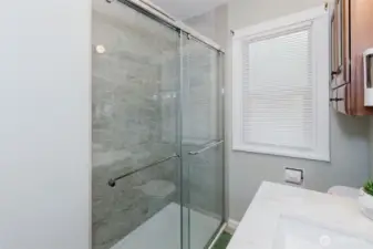 The fully remodeled bathroom features a walk-in shower with fresh finishes and style.