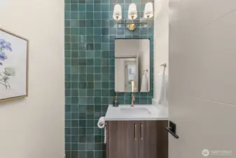 Stylish powder bathroom featuring designer tile work and modern fixtures.