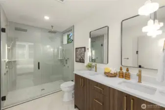 Luxurious primary bathroom boasting a double vanity, contemporary fixtures, and a glass-enclosed shower.
