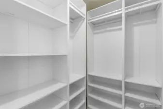 Massive walk-in closet with custom built-in shelving, providing exceptional organization.