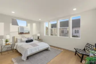 Comfortable guest bedroom with large windows for natural light.