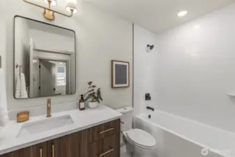 Sleek guest bathroom featuring a modern vanity, clean white finishes, and integrated lighting.