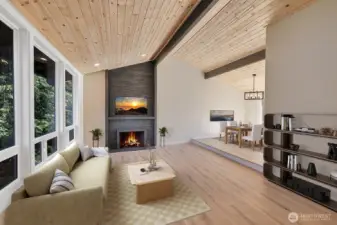 Soaring vaulted ceilings with wood cladding and exposed beams make this living area feel massive. Virtually staged