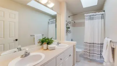 Full bath with skylight services secondary bedrooms