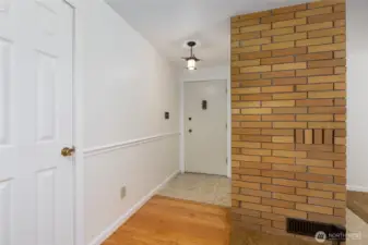 That is inside the front door. It has a tile entry and hardwood floors, with brick fireplace to the right.