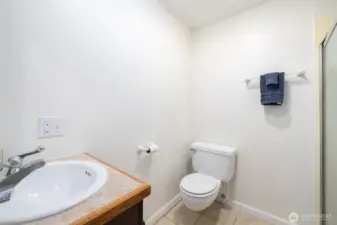 The primary 3/4 bathroom with tile floors and vanity.