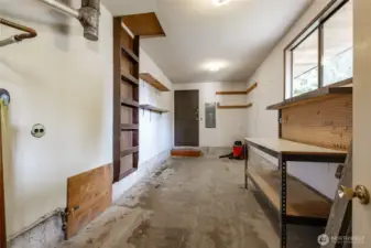 And through the garage, there is a separate workshop with workbench and door leading to the outside. Big windows let in the light.