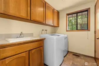 Laundry room with storage galore, sink, and washer / dryer