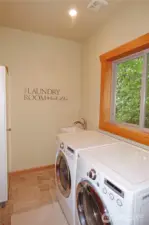 Laundry room with cabinet, sink and washer/dryer (stays with the home). Nice window for fresh air.