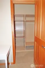 Walk-in closet of #1 bedroom with built-ins and a light.