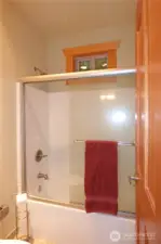 Bathtub and toilet with door between this area and the sink.