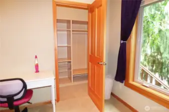 Walk-in closet with builts-ins and a light.