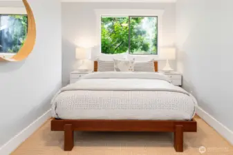 Main floor bedroom with a backdrop of greenery