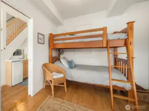 Large flex room downstairs currently used as sleeping quarters with bunk and queen bed with french doors to lower deck with hot tub