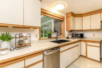 The view out the window is of the backyard, deck, patio and shed.