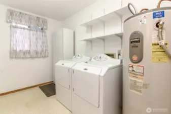 Spacious laundry room with storage and washer and dryer stay.