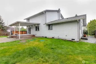 Back yard with paved area to the garage door access.