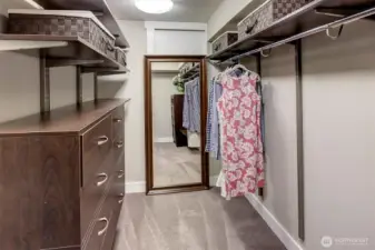 Primary closet with tons of extra storage behind the mirror