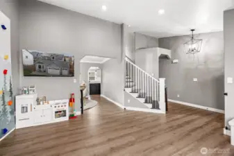 Bright open entry way with vaulted ceilings with updated lighting- this seller uses the "formal living" room as a play area.