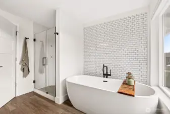 Oversized soaking tub with full tile wall + the full tile shower with a pebble floor- this luxurious bathroom is a must after a hard day at the office.