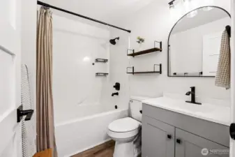 Upstairs hallway full bathroom- the darker fixtures and door handles, stylish mirror, update lighting add to the farmhouse feel of this home.