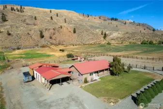 A bright, welcoming exterior photo with the house centered and mountains in the backdrop.