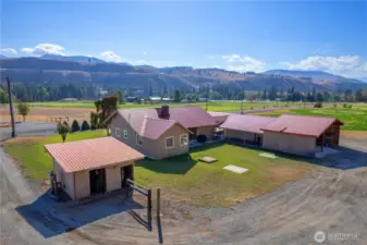 Charming single-level home, and multiple outbuildings, set against a dramatic Methow Valley hillside backdrop.
