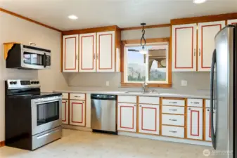 Spacious kitchen with ample cabinetry, stainless steel appliances, and large window bringing in natural light and mountain views.