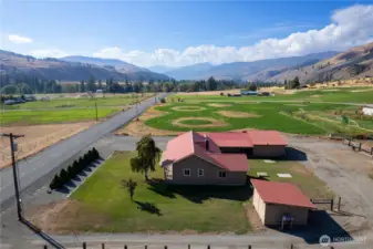 Back property view with open pastures, fencing, and stunning valley and mountain scenery.