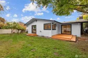 BACKYARD BLISS | Enjoy outdoor living on this deck. Trees have been trimmed to allow light and roof clearance.