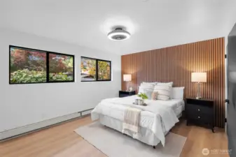 PRIMARY BEDROOM 1 | Located at the back of the home, this is the original primary bedroom, but features modern updates with its beautiful LVP flooring, unique ceiling fan and slatted wall paneling.