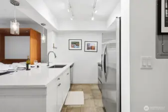 Bright kitchen with stainless steel appliances and quartz countertops.