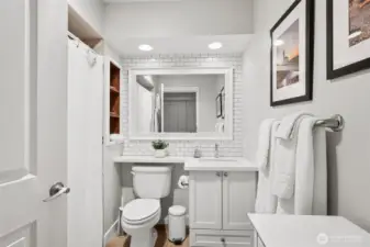 Bright bathroom with upgraded countertops and tile backsplash.