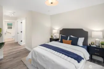 The primary suite features a custom closet system and en-suite bath with an oversized, beautifully tiled shower.